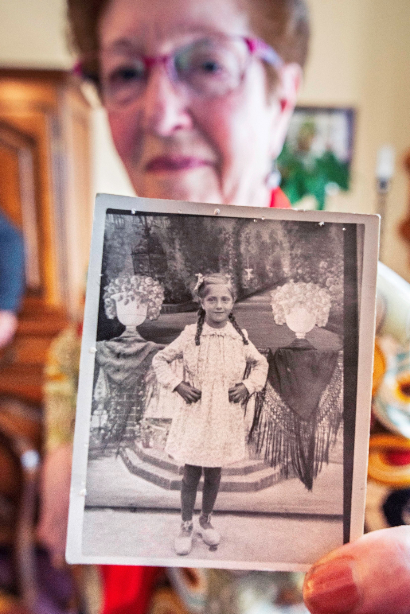 Paquita González muestra la foto que la hicieron de niña, una de las escasas posesiones que le confiscaron a su padre, Francisco, cuando ingresó en un campo de concentración nazi. (EFE)<br>