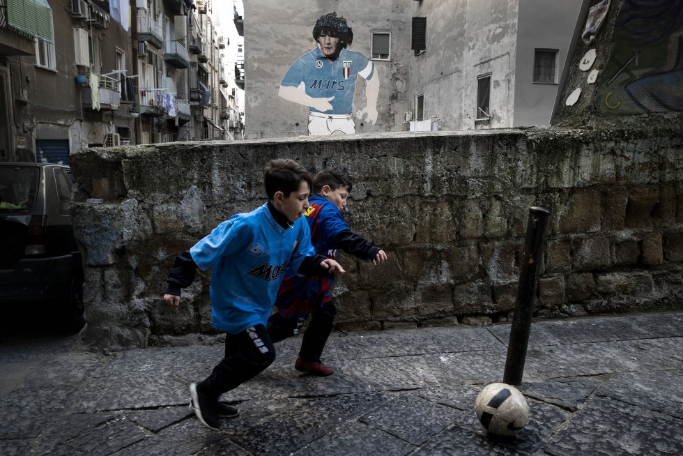 Dos niños disputan el balón en un barrio napolitano de Forcella con las camisetas de Maradona y Messi. (Foto: Paolo Manzo / El País)
